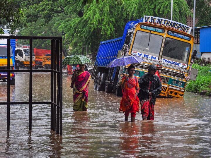 Commuters wade through a waterlogged road amid rainfall, in Chennai. The city is likely to witness light to moderate rainfall throughout the week along with lightning and thunderstorms, the regional meteorological center has forecast. (Source: PTI)