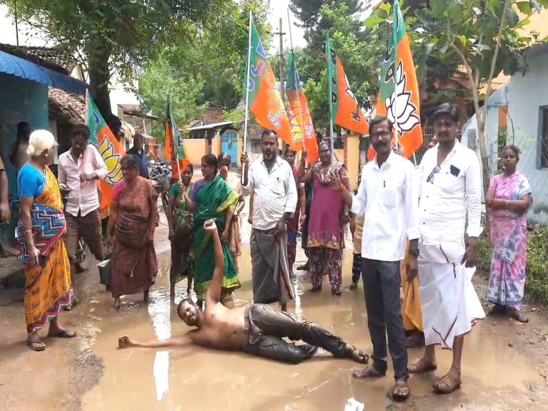 mayiladuthurai: BJP rolled over in the rain water standing on the road TNN மயிலாடுதுறையில் சாலையில் தேங்கி நிற்கும் மழைநீரில் உருண்டு, புரண்டு  பாஜக ஆர்ப்பாட்டம்