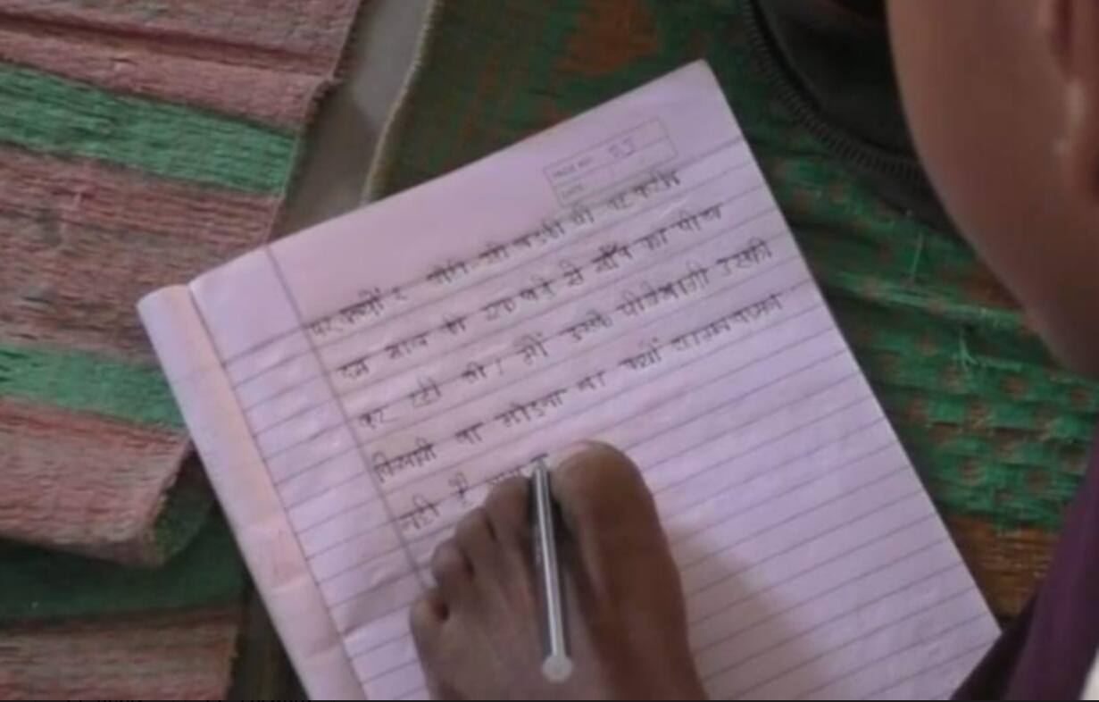 Basti News: हाथों से नहीं पैरों से लिख रहा अपनी किस्मत, दिव्यांग बच्चे के हौसले को सभी कर रहे सलाम