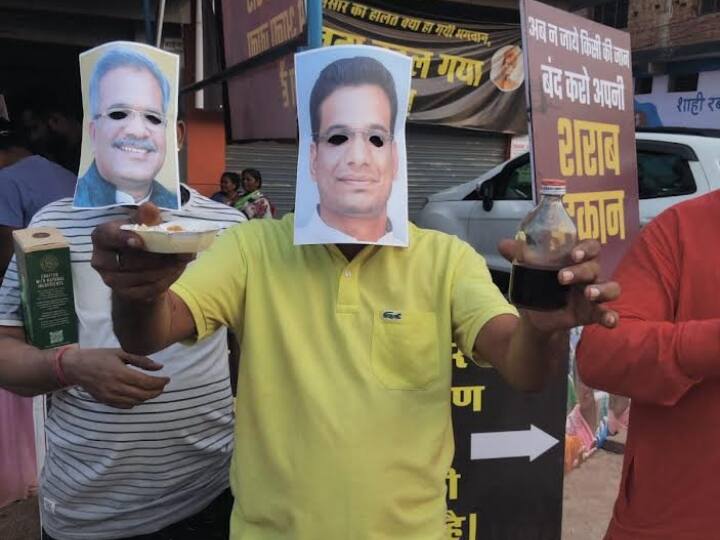 Durg News: शराब की दुकान को हटाने के लिए बीजेपी पार्षद ने अपनाया अनोखा तरीका, सीएम और विधायक का मुखौटा पहनकर बांटा चरखा Durg BJP councilors are protesting to close liquor shop Chhattisgarh ANN Durg News: शराब की दुकान को हटाने के लिए बीजेपी पार्षद ने अपनाया अनोखा तरीका, सीएम और विधायक का मुखौटा पहनकर बांटा चरखा