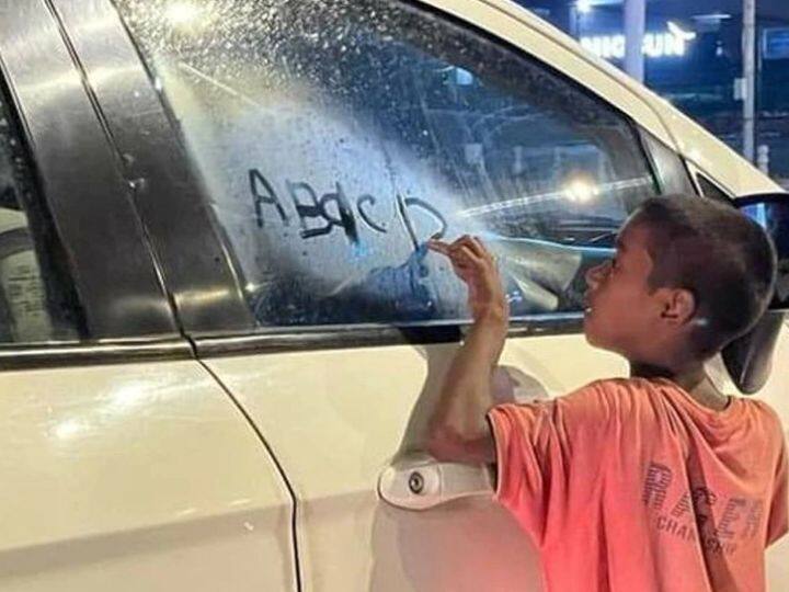 Viral Photo Marathi news child started studying on glass of car picture will touch heart users Viral News : पुस्तक मिळाले नाही, म्हणून मुलाने गाडीच्या काचेवर सुरू केला अभ्यास! हृदयाला भिडणारे चित्र 