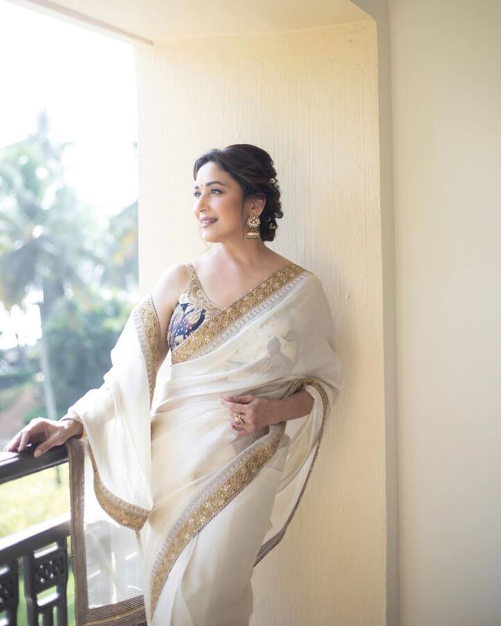 एक बार एक्ट्रेस इस व्हाइट साड़ी में नजर आई थीं. जिसके बॉर्डर पर गोल्डन एंब्रॉयडरी थी. इसे माधुरी ने स्लीवलैस ब्लू ब्लाउज के साथ पहना था.