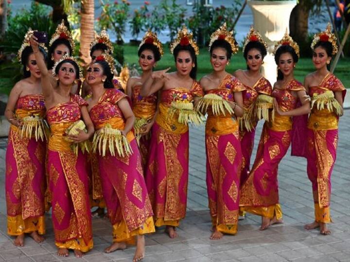 Balinese traditional dancers take selfie as they await the arrival of G20 leaders at Ngurah Rai International airport at Tuban, Badung regency on Indonesia resort island of Bali. (Image Source: AFP)
