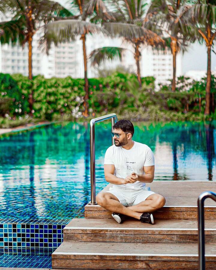 तस्वीरों में कपिल शर्मा को व्हाइट टी-शर्ट और शॉर्ट्स में देखा जा सकता है. उन्होंने अपने लुक को ब्लैक स्नीकर्स के साथ स्टाइल किया.