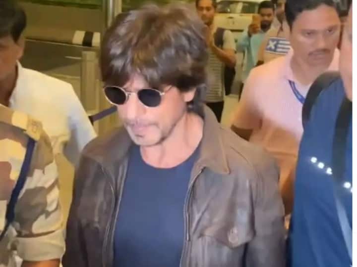 Shahrukh Khan spotted at Mumbai airport photos viral in cool look लेदर जैकेट, मेसी हेयर.... मुंबई एयरपोर्ट पर कूल लुक में स्पॉट हुए Shah Rukh Khan, सिक्योरिटी से घिरे नजर आए 'पठान'
