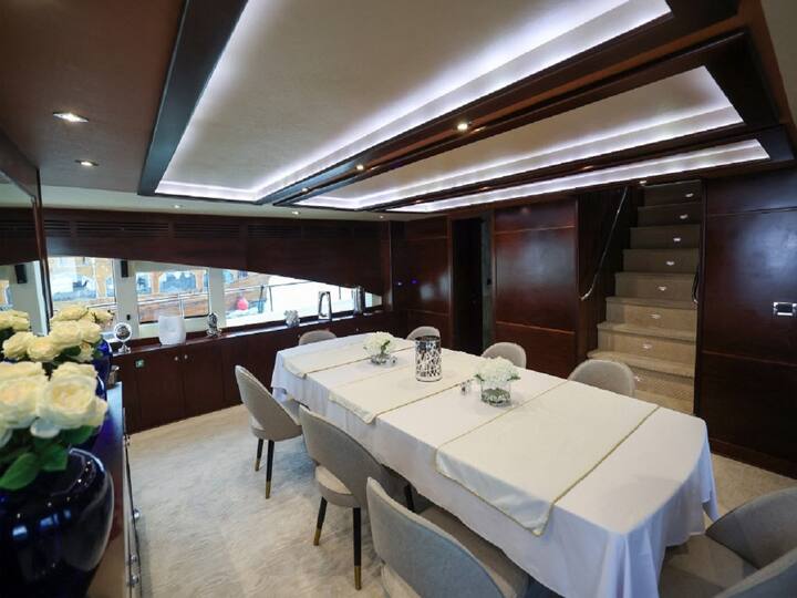 In one of its rooms, a large dining table decorated with upholstered chairs and a bouquet of white roses is laid with glass plates and silver cutlery. ( Image Source: AFP )