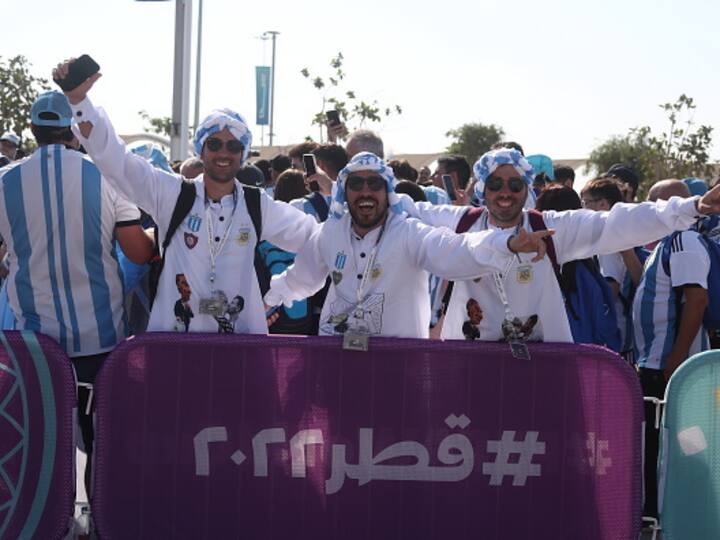 Argentinian fans posing outside the stadium for a picture while holding a banner. Their hopes for glory were forged during an incredible 36-game unbeaten streak dating back to 2019 and have taken on increased poignancy following recent indications from Messi that this will be his last World Cup. (Image Source: Getty)
