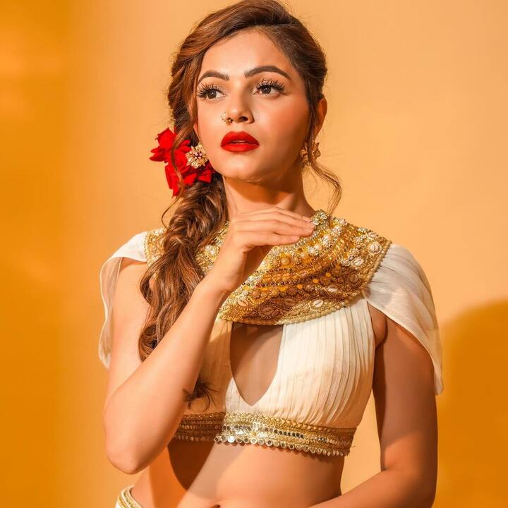 वहीं बात करें लुक की एक्ट्रेस व्हाइट डीपनेक चोली के साथ व्हाइट लहंगा पहने हुए. जिसके साथ उन्होंने मेकअप में रेड लिपस्टिक और बालों में चोटी बनाई हुई है. जिसपर उन्होंने गुलाब के फूल भी लगाए है.