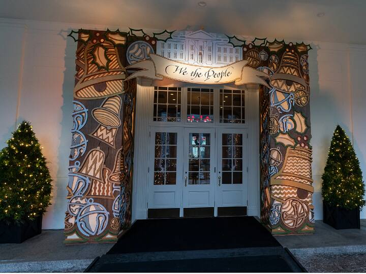 The bells that adorn the White House's East Entrance represent the unifying and healing power of music, welcome visitors with melody and song. The East Wing Lobby's columns and beams are festooned with holiday greenery and scarlet cardinals. Many people believe that the presence of red cardinals indicates the presence of deceased loved ones. The concept of We the People acknowledges the enormous influence of those who came before us. (Image Source: The Official Website Of White House)