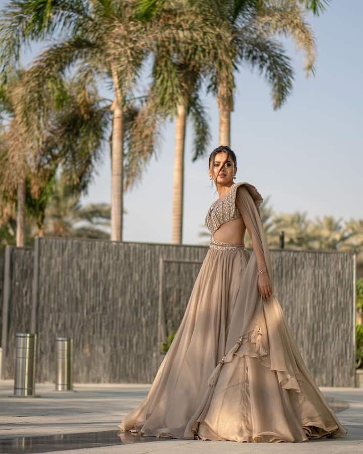 Tejasswi completed her look with dainty pearl studs and her hair styled in a high bun with side locks.