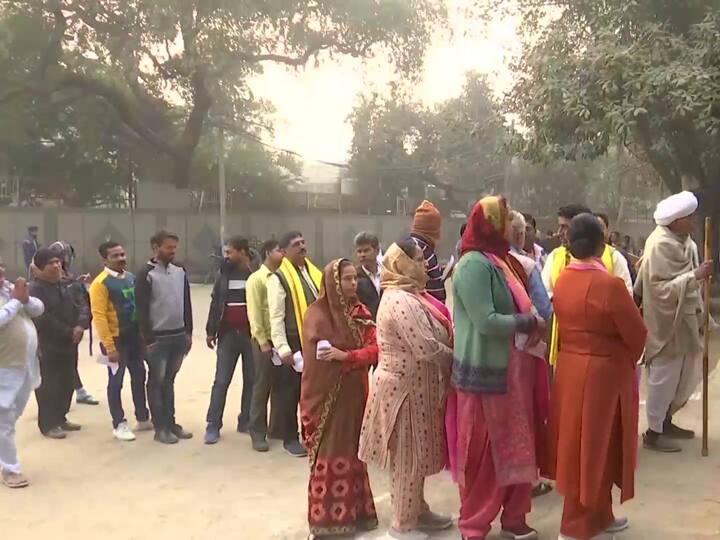 People queue up to cast their votes at a polling booth in Matiala village for the Municipal Corporation of Delhi (MCD) elections. (Source: ANI)