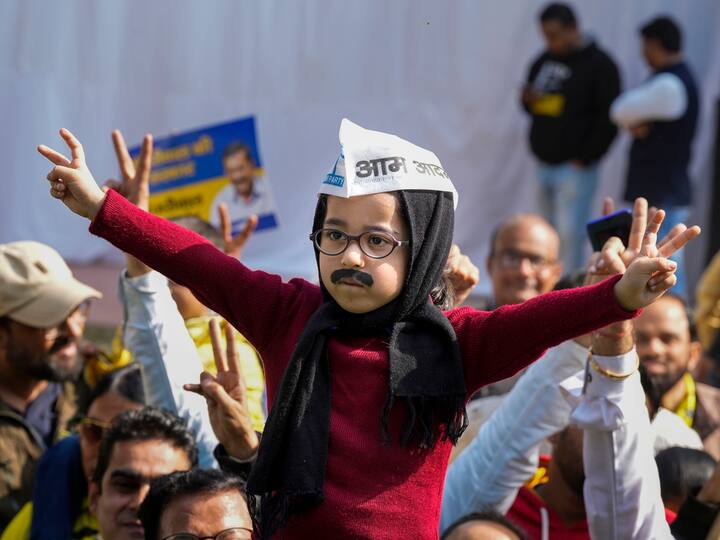 A child dressed in a sweater, an AAP cap with a muffler wrapped around his head, a look sported by Delhi Chief Minister Arvind Kejriwal, seen celebrating outside the party office in Delhi. (Source: PTI)
