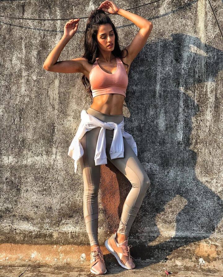 This beige sports bra and leggings of such a color is highlighting her toned abs.