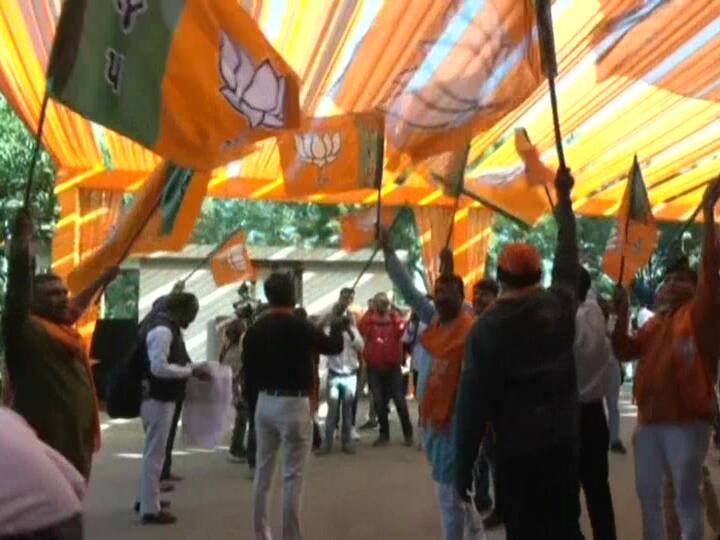 Bharatiya Janta Party worker wave party flags at Gandhinagar office after trends indicate clear lead. (Source: ANI)