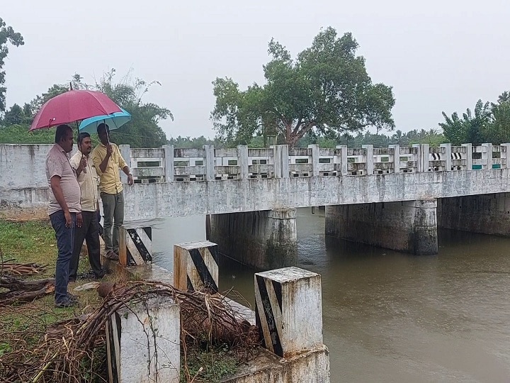 வாழவாய்க்கால் பாலம் உடையும் அபாயம்: கொட்டும் மழையில் குடையை பிடித்துக்கொண்டு ஆய்வு செய்த  அதிகாரிகள்