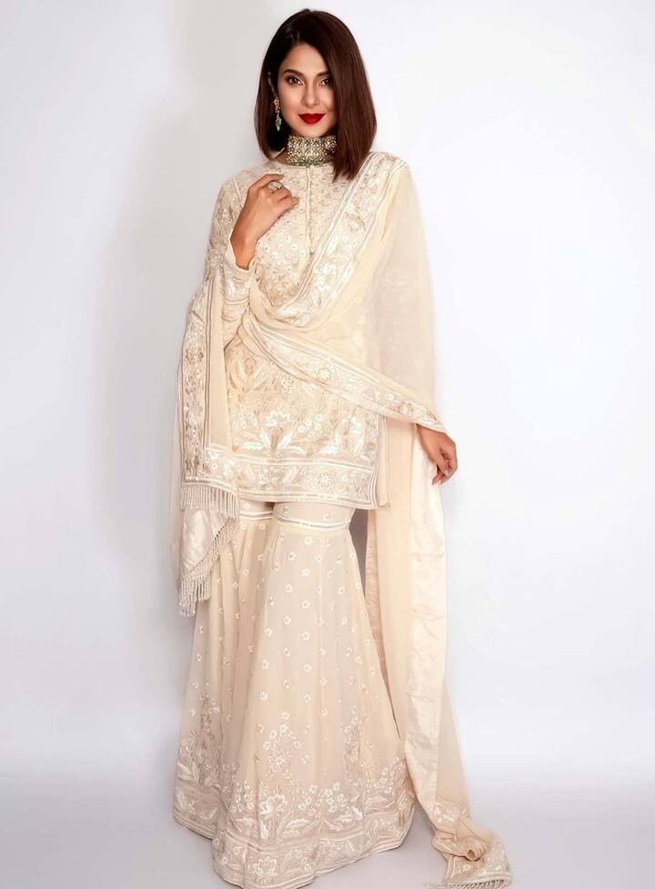 ऑफ वाइट कलर का ये एंब्रॉयडरी वाला शरारा भी काफी एलिगेंट लुक दे रहा है. आजकल शरारा काफी चलन में है तो इसे आप हल्के और सिंपल एंब्रॉयडरी डिजाइन में कैरी कर सकती हैं. जेनीफर ने इसे डार्क लिपस्टिक के साथ पैर किया है. जो कि काफी ग्रेसफुल लग रहा है.