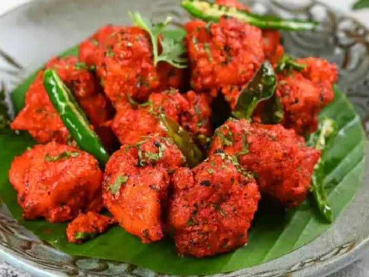 मसाले के साथ दही डालें और अच्छी तरह पकाएं: इसमें थोड़ा सा दही और पानी डालकर अच्छे से पकाएं. फिर फ्राई किया हुआ चिकन डालें फिर मिर्च पाउडर, धनिया पाउडर, चाट मसाला और नमक डालें. ऐसे परोसें: इसे एक प्लेट पर रखें और तले हुए करी पत्ते, कटा हरा धनिया और कटे हुए प्याज के साथ नींबू वेजेज के साथ गार्निश करें.