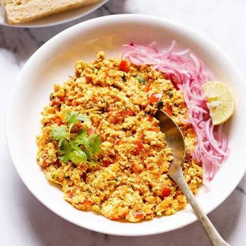 पनीर भुर्जी: एक पैन में तेल गर्म करें. तेल में प्याज़ डालकर हल्का ब्राउन होने तक भूनें, इसके बाद हल्दी के साथ लहसुन, अदरक, हरी शिमला मिर्च, धनिया और जीरा पाउडर डालें. बघार जब बन जाए तो इसमें टमाटर प्यूरी डालें और अच्छी तरह मिलाएँ. आखिरी स्टेप में पनीर को क्रम्बल करके पैन में डालें और 5 मिनट तक पकने दें. अब स्वादनुसार नमक डालें और आपकी पनीर भुर्जी तैयार है.