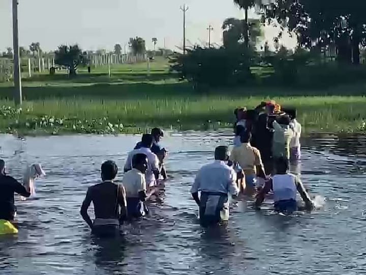 இறந்தவர் உடலை அடக்கம் செய்வதற்கு கழுத்தளவு நீரில் ஆபத்தான முறையில் பயணம் செய்யும் ஊர்மக்கள்