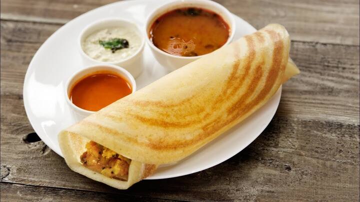 தோசைக் கடாயின் மையத்தில், ஒரு கரண்டி தோசை மாவை ஊற்றவும்.பிறகு அதனை கல்லில் நன்கு வட்டமாகத் தேய்க்கவும்.