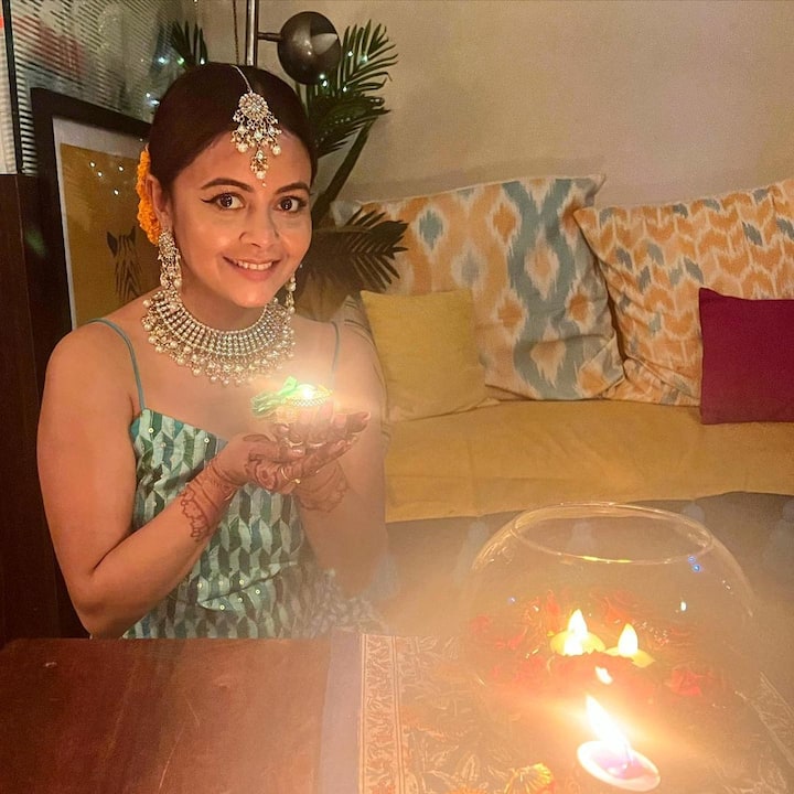 घर का लिविंग रूम काफी बड़ा है. जहां पर ग्रे कलर का सोफा लगाया गया है और उसपर मल्टी कलर के कुशन रखे गए है.