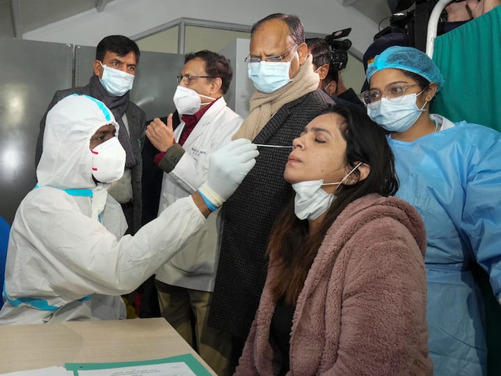 Union Health Minister Mansukh Mandaviya speaks with a doctor as a medic collects swab sample of a woman, during a nationwide mock drill for COVID-19 preparedness, at Safdarjung hospital in New Delhi on Tuesday. (Source: PTI)