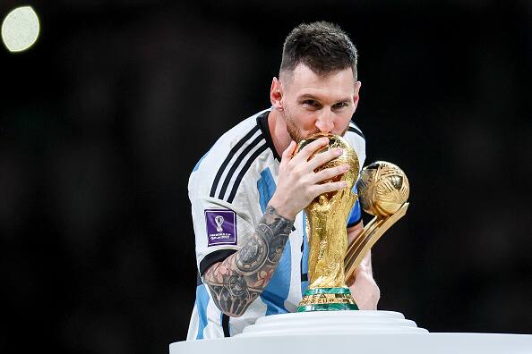 Argentina's Lionel Messi pictured as he kisses FIFA World Cup 2022 Winners' Trophy while holding the Golden Boot award after WC Final match between Argentina and France at Lusail Stadium on December 18, 2022 in Lusail City, Qatar. Argentina defeated France 4-2 on penalties to win their 3rd FIFA WC trophy. Pic Courtesy: Getty Images 