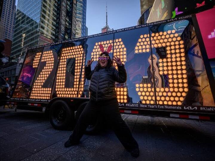 Actor and Producer Teresa Hui poses in front of the lit New Year 2023 numerals in Times Square, New York, hoping that the coming year will allow us to start over and strive towards rebuilding the world even if Covid-19 cases rise again. (Image Source: AFP)