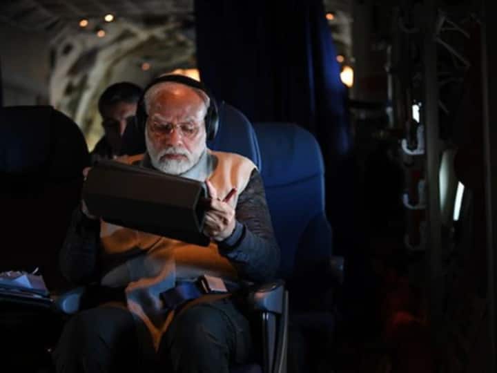 प्रधानमंत्री अपने दौरे के दौरान हवाई जहाज में काम करते हुए.