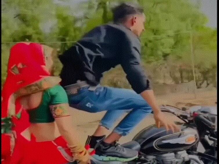 WATCH Man Performs Dangerous Stunt On Bike With Wife As Pillion Rider Netizens Seek His Arrest Man Performs Dangerous Stunt On Bike With Wife As Pillion Rider, Netizens Seek His Arrest