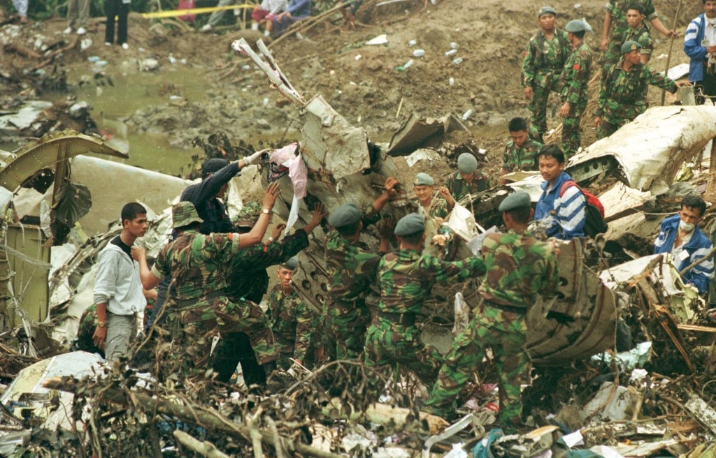 Soldiers and investigators (in blue) search for the black box from the wreckage of the Indonesian Garuda Flight 152 which crashed near Medan, in northern Sumatra on September 26, 1997, leaving all 234 passengers and crew on board dead.