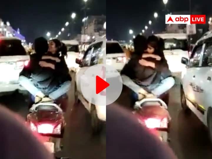 Lucknow Hazratganj Couple romances on scooty Video with risk stunts their lives viral on Social Media Watch Video Watch: कपल ने चलती स्कूटी पर किया रोमांस, जान जोखिम में डालकर यूं किया स्टंट, इंटरनेट पर छाया वीडियो
