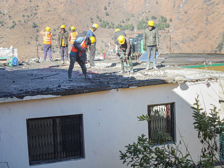 Workers demolish a building in the land subsidence affected area. The DM directed the Rural Works Department (RWD) to provide a contour map of the land in Dhak village in Joshimath soon.(Source: PTI)