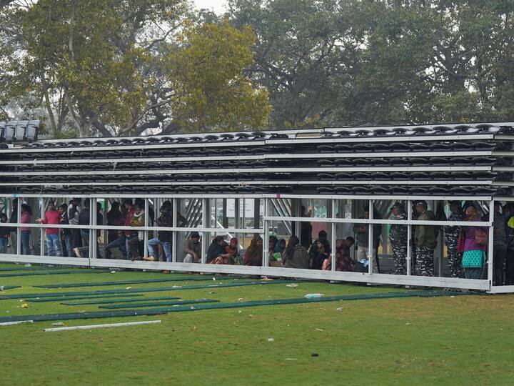 People take shelter amid rains at a shade on the lawns near India Gate. (Image Source: PTI)