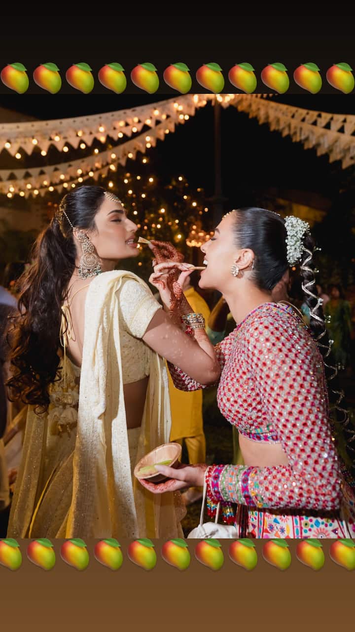 In another picture, bride Athiya can be seen sharing a fun-filled moment with Tania as they enjoy phirni together at mehendi ceremony.