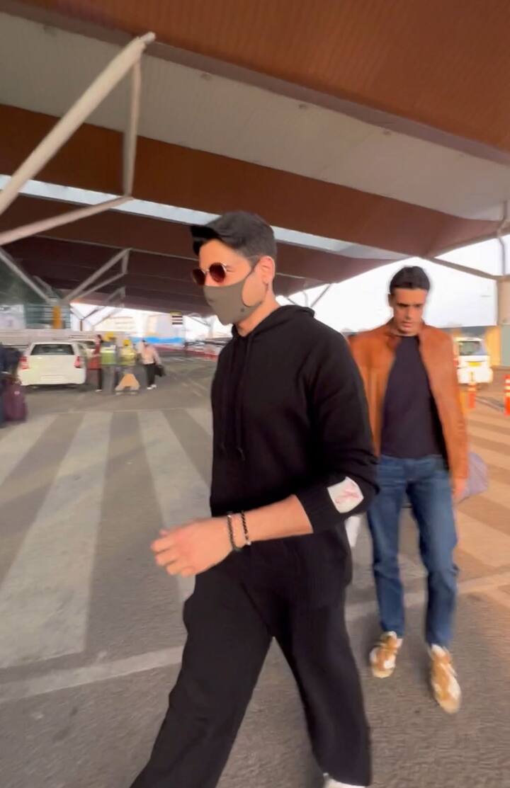 सिद्धार्थ ने ब्लैक स्वेटशर्ट के साथ ब्लैक लूज पायजामा और सिर पर ब्लैक टोपी पहनी हुई है.