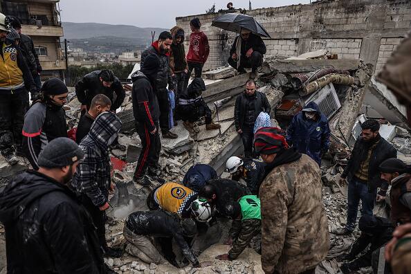 The Syrian Civil Defense, commonly known as the White Helmets, attempts to save people from the wreckage. (Source: Getty)