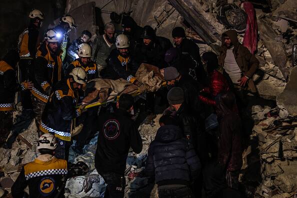 Rescue workers struggle to rescue individuals trapped beneath a collapsed building after a magnitude 7.8 earthquake struck Syria.(Source: Getty)