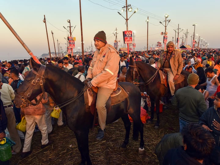 Horse-mounted policemen monitor devotees gathered to take holy dip at Sangam, the confluence of the rivers Ganges, Yamuna and mythical Saraswati, on the occasion of Magh Purnima, during the ongoing Magh Mela in Prayagraj, Sunday, Feb. 5, 2023. (Source: PTI)