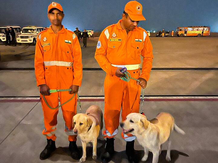 Two members of the NDRF search and rescue teams with specially trained dogs stand before they depart for earthquake-hit Turkiye. (Source: PTI)