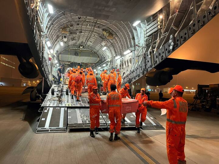 Members of NDRF search and rescue teams along with relief material and specially trained dog squads board the IAF aircraft for earthquake-hit Turkiye. (Source: PTI)