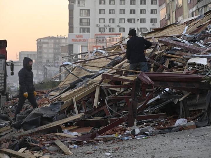 People clear debris from a mountain of rubble in Antakya in attempts to check whether there's someone trapped under it or not. (Image Source: Getty)