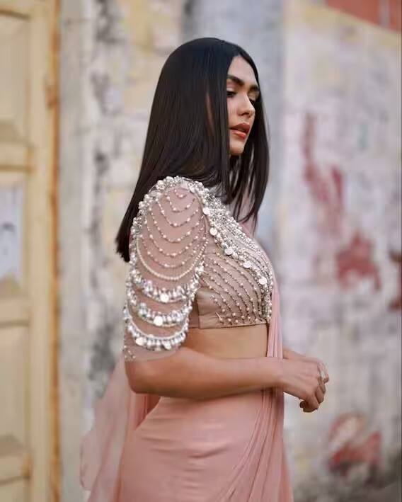 या गुलाबी रंगाच्या रेडी टू वेअर साडीमध्ये मृणाल अतिशय सुंदर दिसतेय. ही साडी डिझायनर रिद्धी मेहरा हिच्या कलेक्शनमधून घेण्यात आली आहे. चांदीचं जरी भरतकाम असलेला लांब बाह्यांचा ब्लाउज तिच्या सौंदर्यात अधिक भर घालतोय.