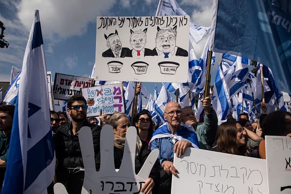 Tens of thousands of Israelis demonstrated outside the parliament building Monday, flying flags, blowing horns, and yelling 