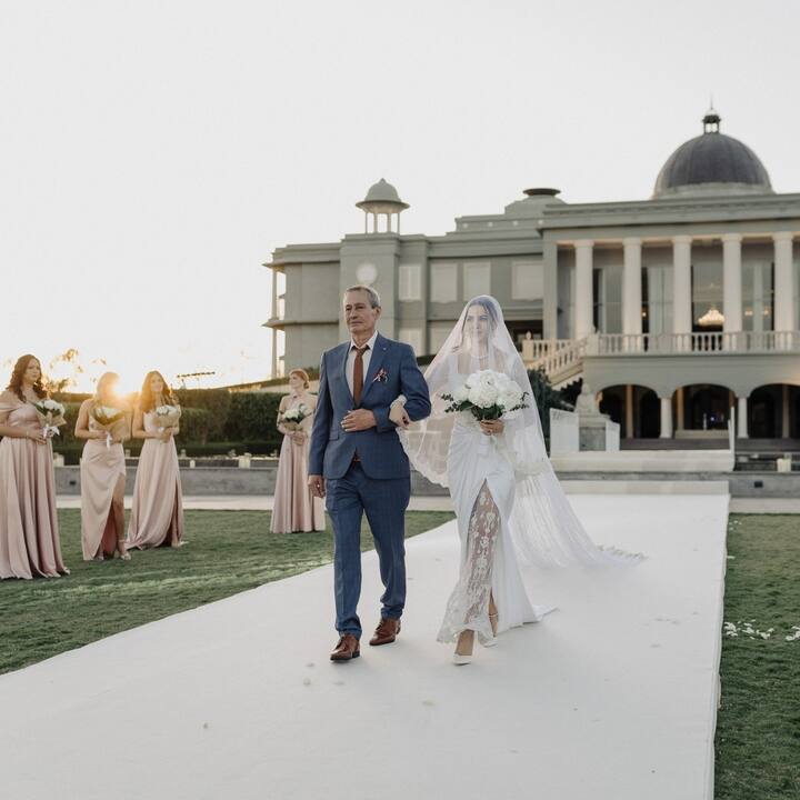 Another photo shows Natasa walking down the aisle with her father.