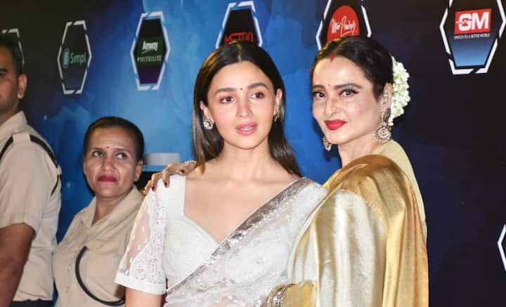 কিন্তু সোমবার লাল কার্পেটে ঘুচে গেল সেই সব দূরত্ব, ফারাক। বরং হাতে হাত রেখে, হাসিমুখে এক ফ্রেমে যখন ধরা দিলেন রেখা এবং আলিয়া ভট্ট, পাপারাৎজি থেকে কলাকুশলী, মন্ত্রমুগ্ধের মতো তাকিয়ে থাকলেন সকলেই।