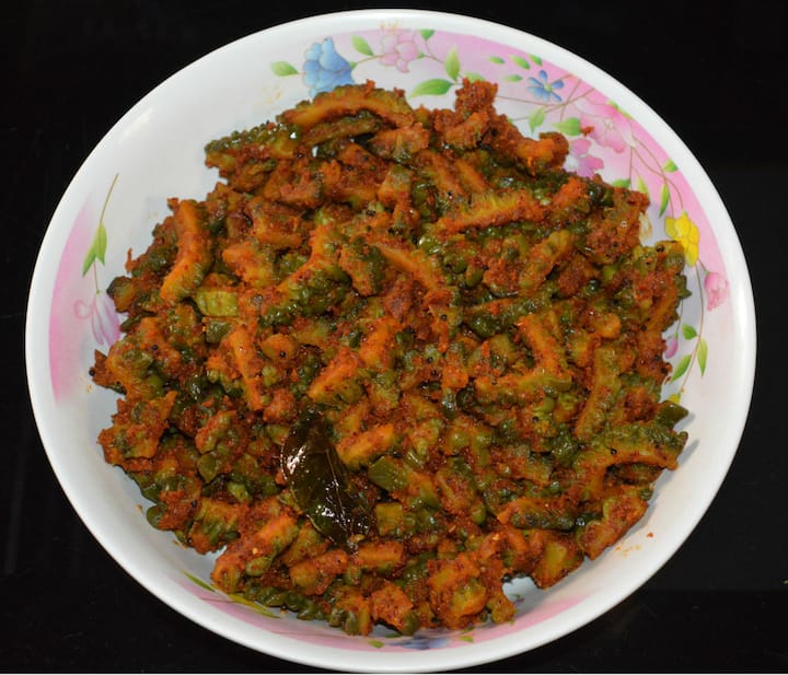 பின்பு, கடாயில் எண்ணெய் ஊற்றி, வெங்காயம், பூண்டு, கறிவேப்பிலை சேர்த்து தாளிக்க வேண்டும். பின்பு, நறுக்கி வைக்கப்பட்ட பாகற்காய் இதில் போட்டு 20 நிமிடம் வதக்க வேண்டும்.