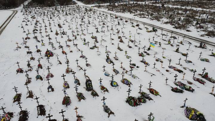 An aerial view of a cemetery with soldiers buried underneath in Ukraine. With no signs of any seize fire from any side, the battle is expected only to intensify. A day after Biden's secret visit to Ukraine, on February 21, Vladimir Putin gives a speech at the parliament blaming the West for 