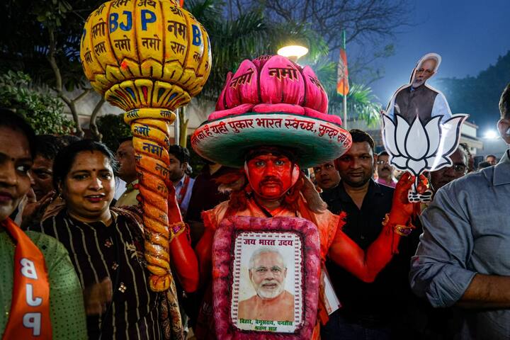 A BJP supporter with others during celebrations after the party's performance in Nagaland, Tripura and Meghalaya Assembly polls, at the BJP HQ in New Delhi, Thursday. (Source: PTI)