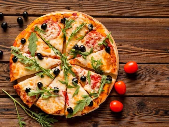 स्वादिष्ट और लजीज पिज्जा खाना किसे पसंद नहीं है. यह स्नैक हो या भोजन, पिज्जा परम आराम का भोजन है जो सभी उम्र के लोगों द्वारा पसंद किया जाता है। इस महिला दिवस, ऑलिव कॉर्न पिज़्ज़ा की इस सुपर आसान रेसिपी को आज़माकर खाने के लिए अपने प्यार का जश्न मनाएँ। केवल कुछ सामग्री से बना यह ऑलिव कॉर्न पिज़्ज़ा केवल 10 मिनट में बनकर तैयार हो जाता है और इसे बेक करने में केवल 10-12 मिनट का समय लगता है. हमने सब्जियों के रूप में जैतून, मकई और पीली शिमला मिर्च डाली है, लेकिन आप पिज्जा को स्वादिष्ट और अतिरिक्त स्वादिष्ट बनाने के लिए प्याज या मशरूम भी डाल सकते हैं. सुनिश्चित करें कि आप पिज्जा को उसका सिग्नेचर चीज़-पुल इफेक्ट देने के लिए मोज़ेरेला चीज़ का उपयोग करें. अगर आपके पास मोज़ेरेला चीज़ नहीं है, तो आप अपनी पसंद के किसी भी चीज़ का इस्तेमाल कर सकते हैं। चाहे पार्टी हो, बुफे, पिकनिक, जन्मदिन या कोई अन्य विशेष अवसर, आप इस स्वादिष्ट ओलिव कॉर्न पिज्जा को बनाकर अपने मेहमानों को प्रभावित कर सकते हैं. इस रेसिपी को आजमाएं, इसे रेट करें और हमें बताएं कि यह नीचे दिए गए अनुभाग में एक टिप्पणी छोड़ कर कैसी बनी.